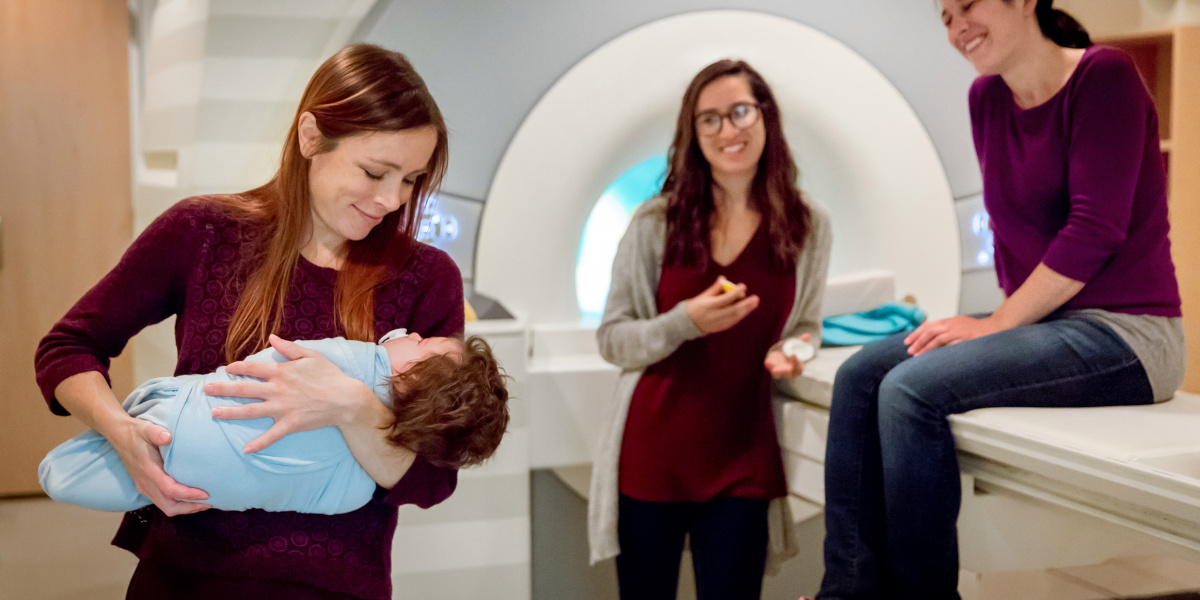 Heather Kosakowski holds an infant who is about to be scanned in an fMRI machine at the McGovern Institute for Brain Research.