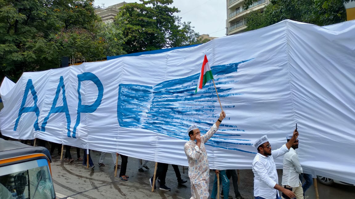 AAPMaharashtra's tweet photo. 'Your ignorance on corruption is their power'. It's time to sweep the ignorance.

Singing the slogans of Independence, the rally has reached juhu.
#ImandaariKiTopi https://t.co/Id8w3o7SMr