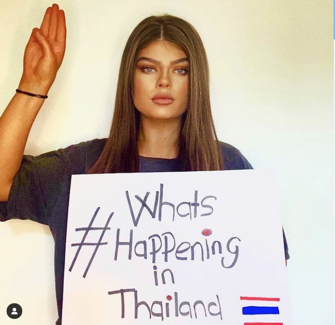 Miss Grand Scotland 2020 Helen Maher posted a photo of herself holding up a #WhatshappeninginThailand sign with the three-finger salute on Friday. #ม็อบ15สิงหา