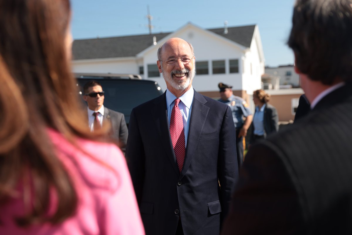 Governor Wolf smiling in between two people