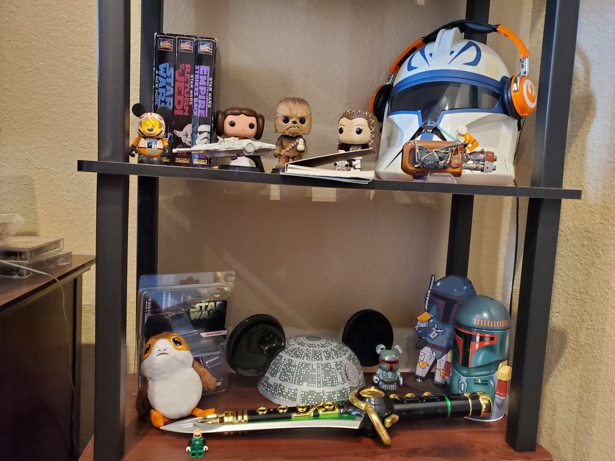tanganniew's tweet photo. #ArchivistsHomeCollections: I collect Star Wars memorabilia! I still have the original trilogy on VHS, THX remastered where Han shot 1st, w/ no CG scenes. (Game: Can you spy what doesn't belong on these shelves? 😅) What do you collect? Use our tags and share! #saa21 #saa2021 https://t.co/0NInoAjtwy