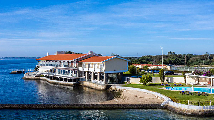 YourKeyToTravel's tweet image. The Pousada da Ria is located in #Torreira #Portugal on a peninsula that acts as a barrier between the Atlantic Ocean and the #Aveiro Lagoon. The building is built on pillars above the water, and provides an up-close and special connection with nature. bit.ly/3yF6d9K