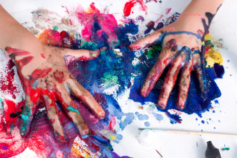 2 kids' hands mixing different colour paint in an art project.