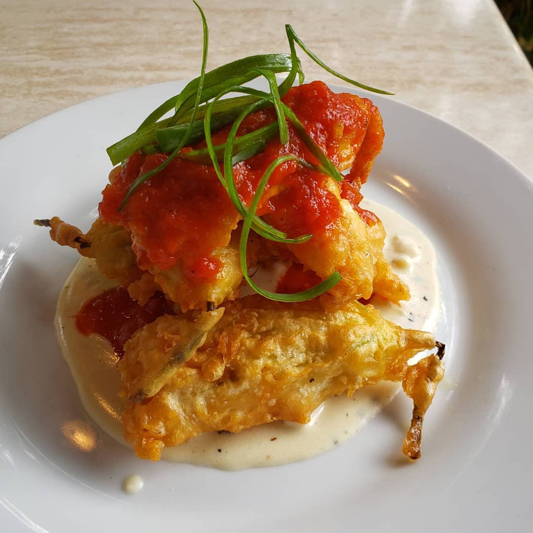 Our Squash Blossom Beignets with Goat Cheese Fondue &amp; Tomato Coulis are a summer sensation, best savored on our garden patio with a glass of fresh, fruity rosé.
315santafe.com