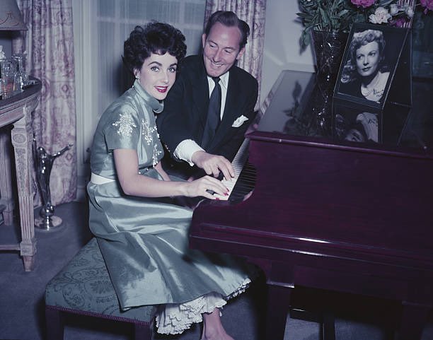 Elizabeth Taylor and her husband Michael Wilding pictured at home in their apartment in England, circa 1952.