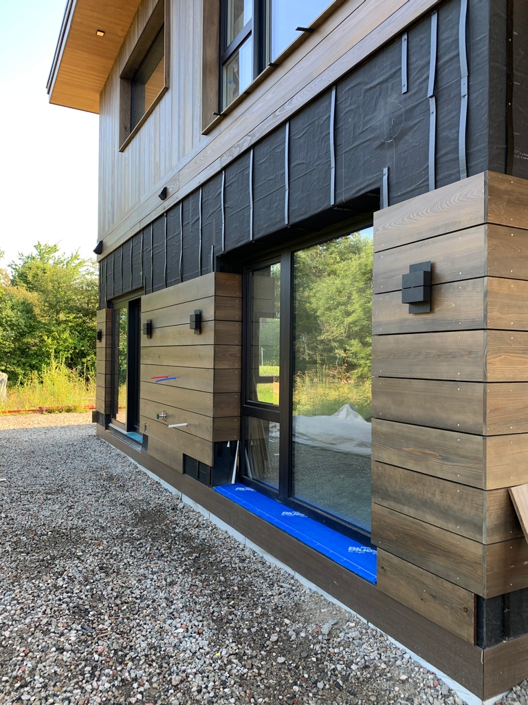 NPTRE's tweet photo. The exterior lighting is going in at our #sachuestbuild. We love the design of these outdoor wall sconces against the siding! 
#customhomedesign #NPTREdesignbuild #rhodeislandhomes #netzerohome https://t.co/SWNVTf0tI3