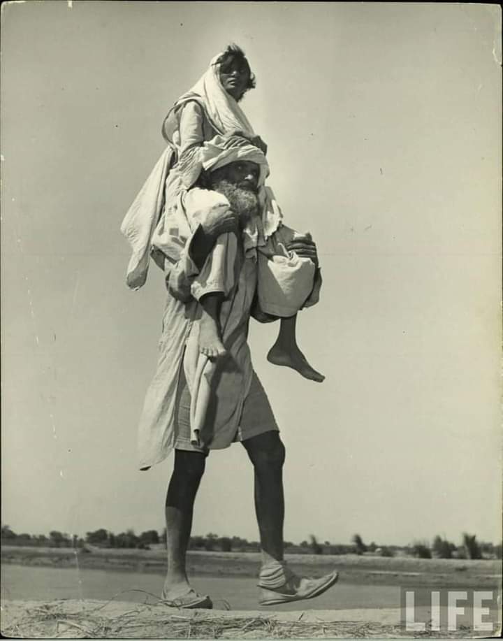 Zaintws's tweet photo. Man carrying his daughter on his shoulders on the way to Pakistan. #Partition1947 https://t.co/FuDZQqYTug