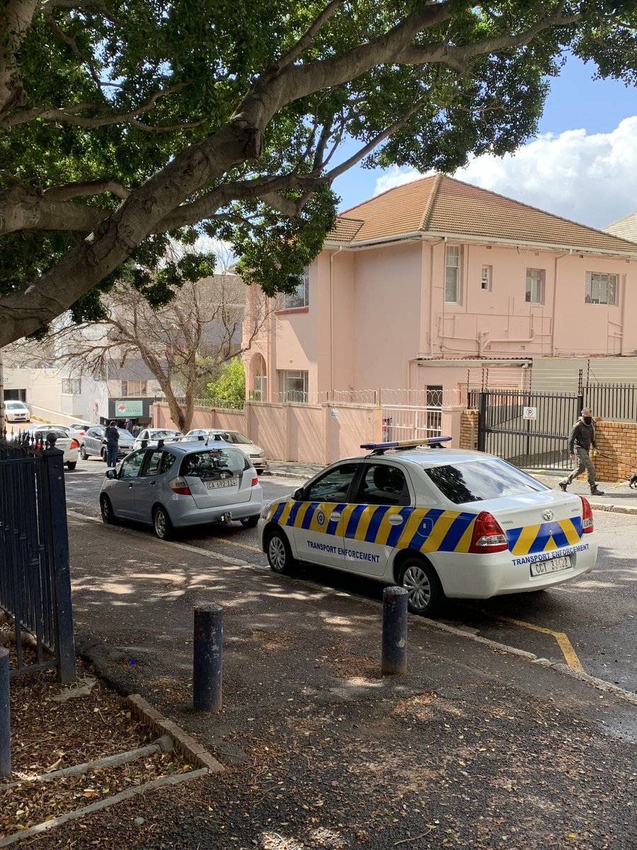 Metro officer 👮 giving out fines at the back there for cars parked on the yellow line. Meanwhile you’re not setting a good example yourself. #touché <a href="/CityofCT/">City of Cape Town</a> btw, I’m happy that cars don’t park in the street here as it’s quite narrow and people honk 24/7/365