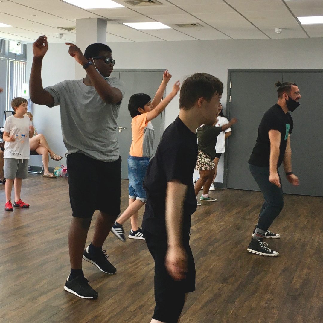 Group of young people wearing casual clothes, learning a dance routine in a dance studio