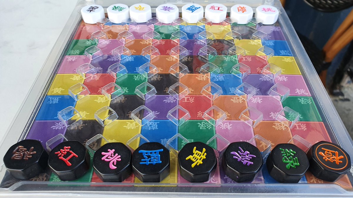 Kamisado pocket set up, starting the second round. Black has a Sumo Dragon, the orange piece.