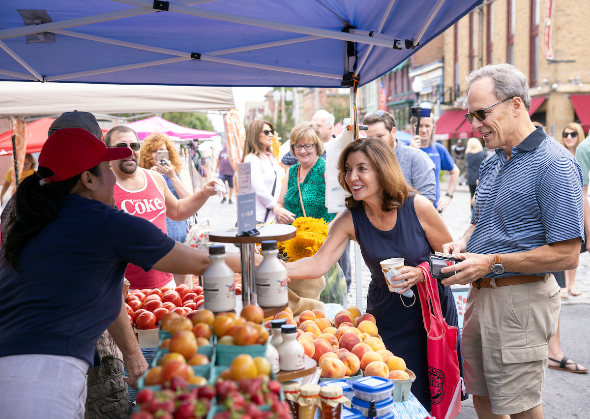 Governor Hochul shakes hands with a person at the Washington Park Farmers Market.
