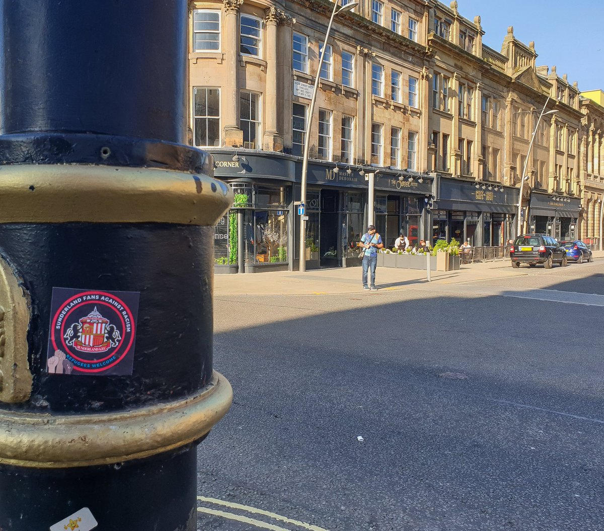 SteMartPhotos's tweet photo. A few stickers around the city centre today. I argued with a bloke near me over his childish booing of the knee, he took offence to me clapping. Most around me backed me up and hearing the cheers drown out the minority booing was great 👍 

@SunderlandUnite 
@Safc_FLAF https://t.co/bsGRfUZvlU
