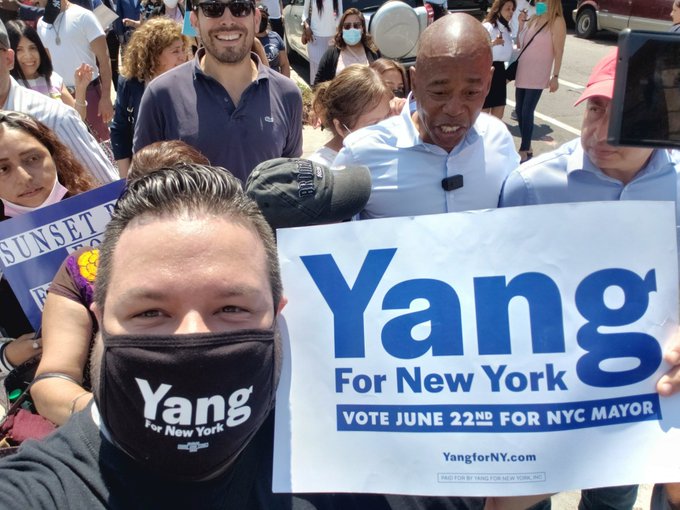 NelNieves's tweet photo. I was looking at photos of @AndrewYang on Adobe Stock for a project I'm working on but was curious what photos might be on there and came across this one of me taking a selfie in front of @ericadamsfornyc while holding my YangForNY placard!!! 2nd pic is my selfie!!! https://t.co/cJbLDBpGw4