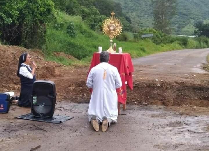 monsalfonso's tweet photo. Habitantes de Maruatillo, Coalcomán, de la parroquia de Ntra. Sra. de Guadalupe, Aguililla, Mich., acompañados de su párroco y religiosas, rezan el rosario ante el Santísimo, junto a la carretera destrozada, pidiendo por la Paz en toda la Región https://t.co/nKOD1ob8lO