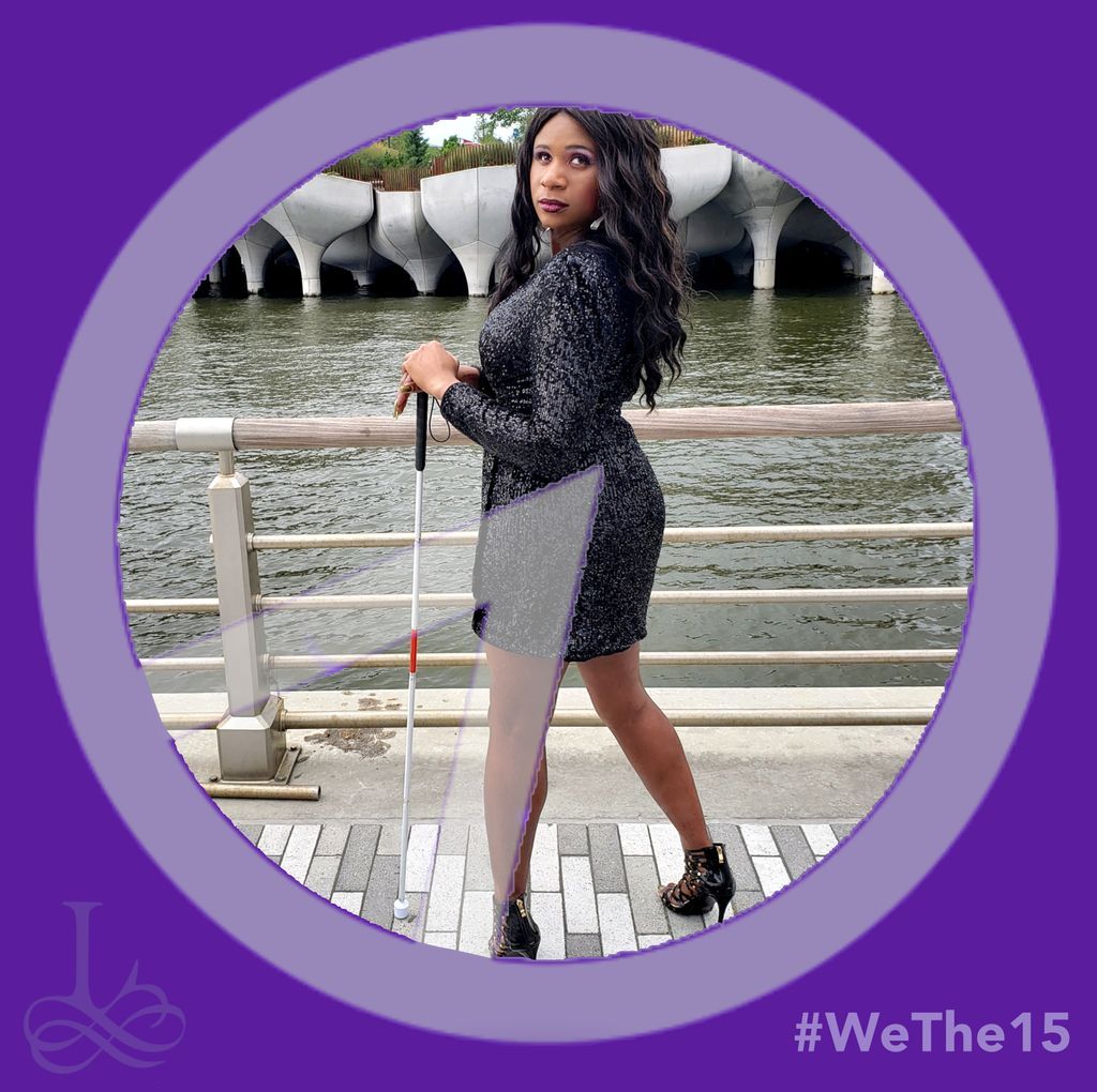  Lachi poses on a bridge in a black dress and heels holding a white cane. The image is within a purple border and a transparent We The 15 logo sits above. The We The 15 logo is a white outlined circle with 1/6th pie sliced out. In the right corner reads Wethe15 and the Lachi logo in the other. 