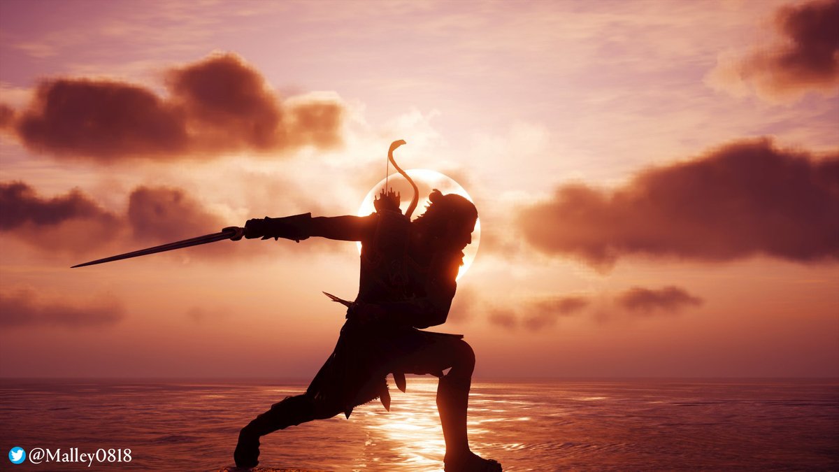 An in-game photo of Assassin’s Creed Odyssey by Malley0818 on Twitter. The photo shows Alexios, silhouetted by the setting sun with blades in hand as he completes an attack. One arm is extended behind him, sword pointed away from his body, the other rounds his mid-section. He stands atop a thin layer of water that reflects the rich amber light of the sunset and the shadows of distant clouds.
