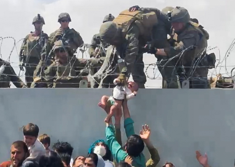 inquirerdotnet's tweet photo. LOOK: A baby is handed over to the American army over the perimeter wall of the Kabul airport for it to be evacuated on August 19, after the Taliban took over Afghanistan’s capital. | 📷Omar Haidari via Reuters https://t.co/KbywEd5OJo