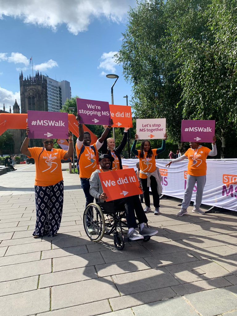 Friends and family hold up place cards saying MS Walk and We did it.