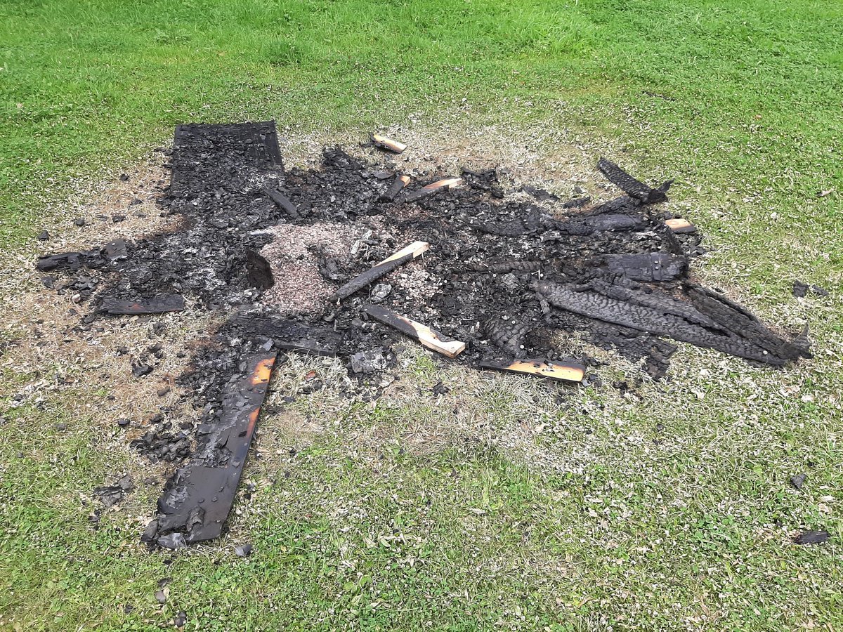 The burnt remains of a large wooden structure featuring locations and experiences of women experiencing street harassment in Sheffield.