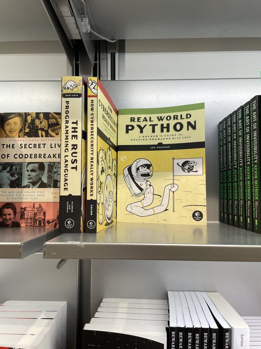 Bookshelf at the Spy Museum bookstore- includes books about Python and Rust programming languages.