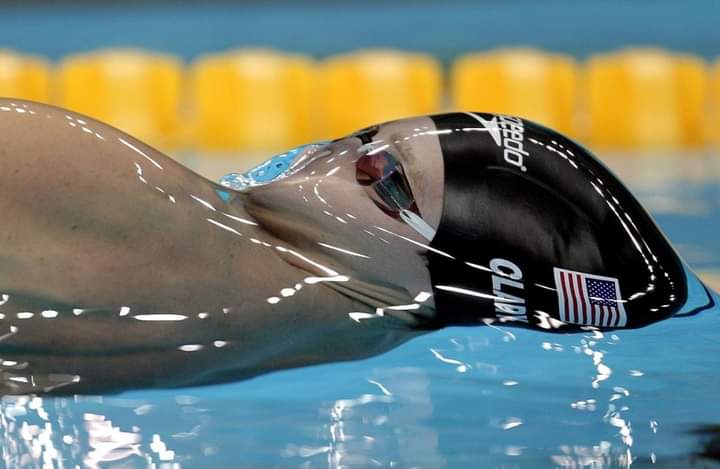 Momento exacto de un nadador antes de romper la tensión superficial.