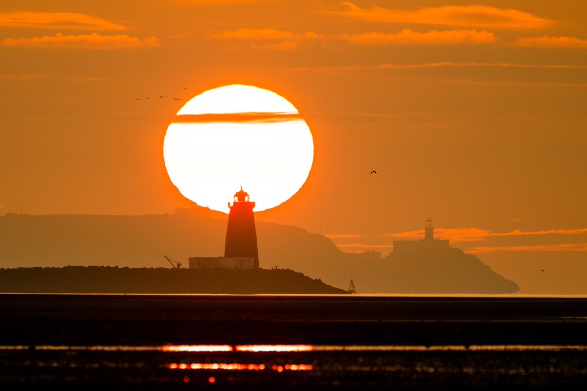 The sun rising this morning behind Poolbeg lighthouse with the Baily lighthouse in the distance #sunrise #dublin #ireland