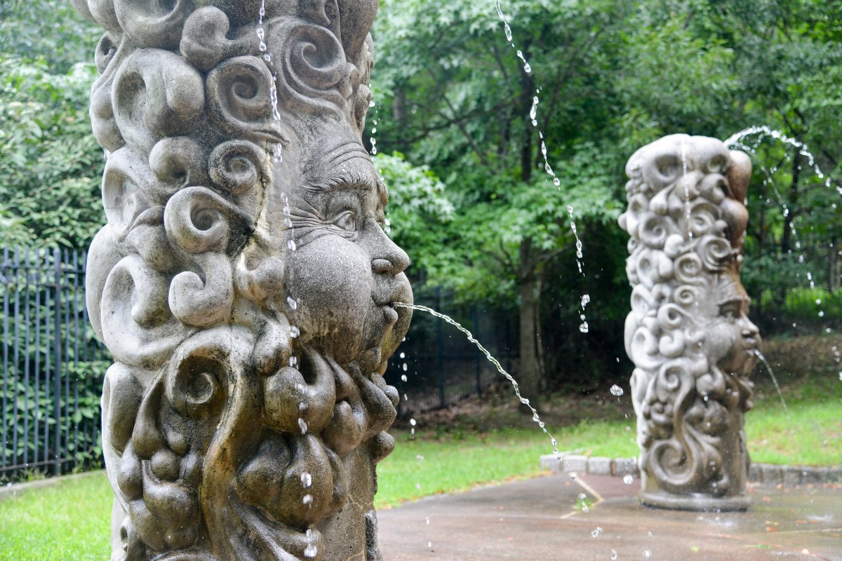 Two columns carved into clouds and angel faces spout water into a circle where kids play