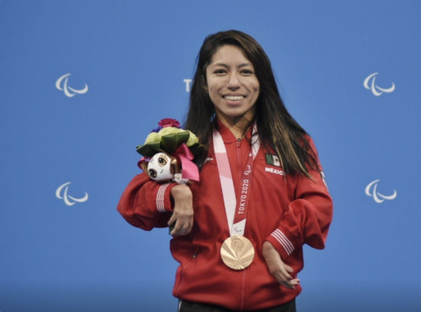 La atleta Fabiola Sánchez, con su uniforme rojo, sonriendo de frente y con su medalla de bronce en el pecho.