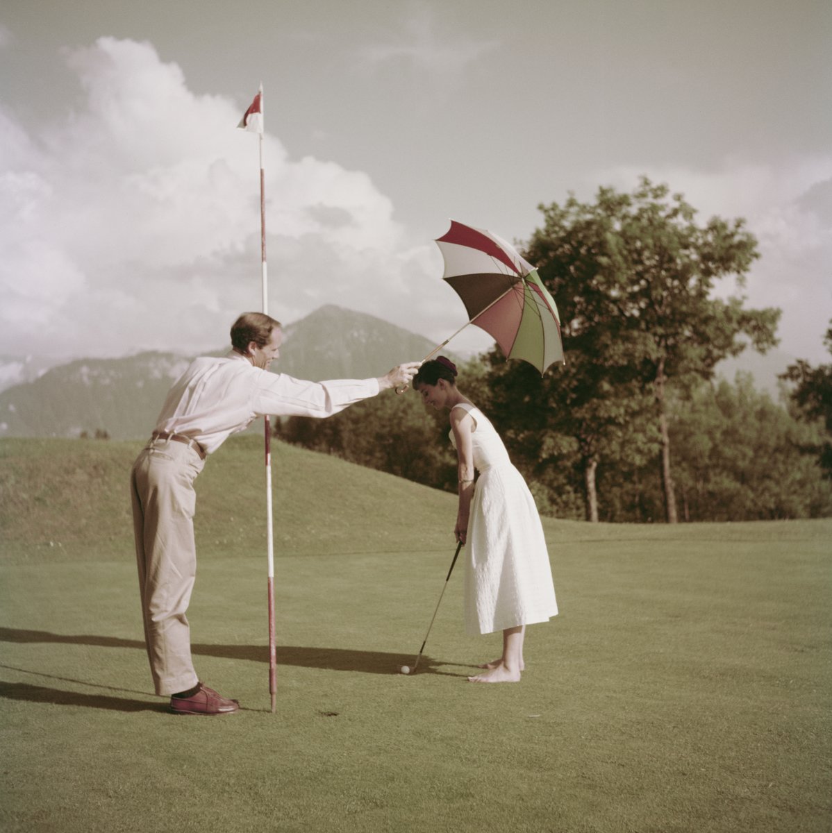 Audrey Hepburn playing golf with her husband in Switzerland. 1954.