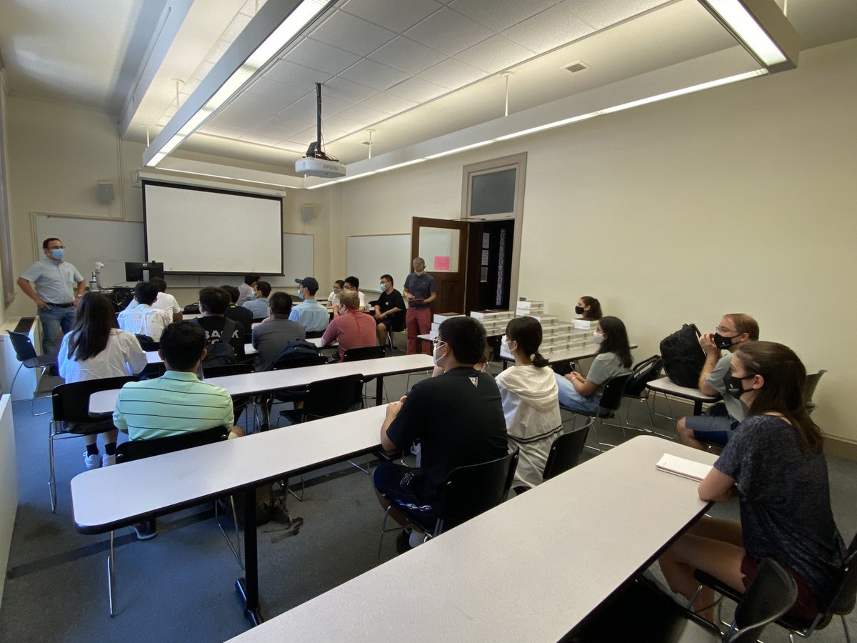 Classroom with masked students looking on as a professor speaks.