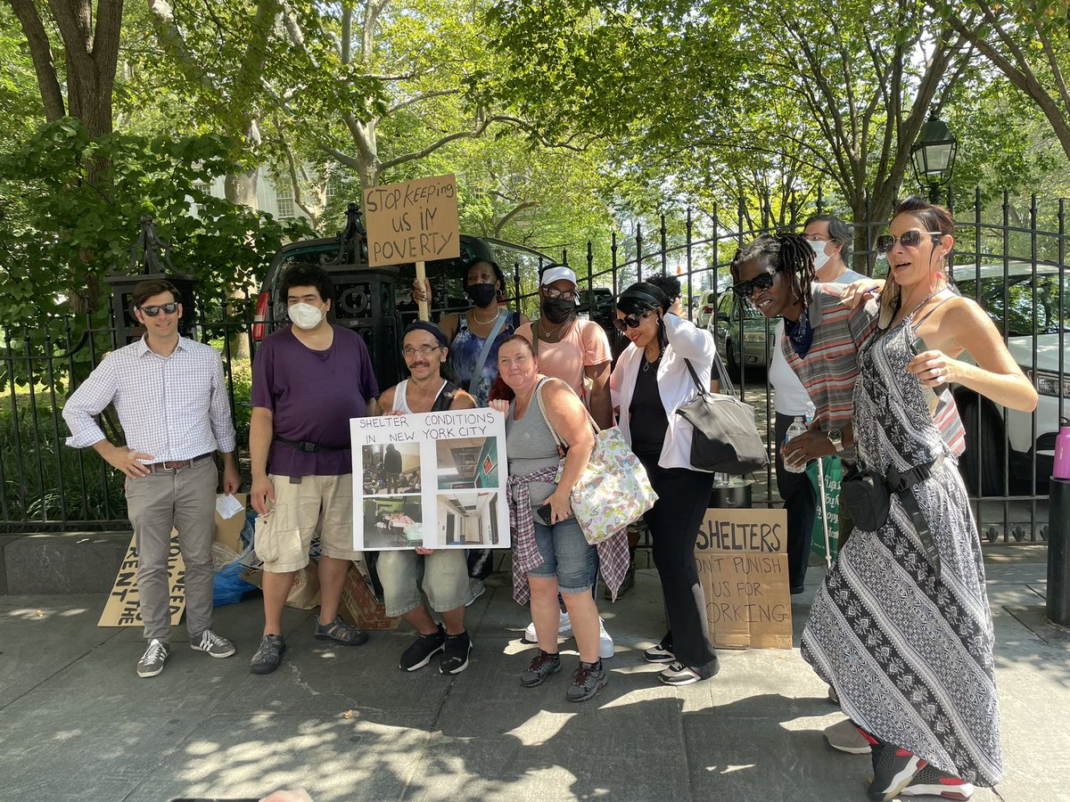 Activists protesting outside of NYC City Hall. About 17 people, with signs.