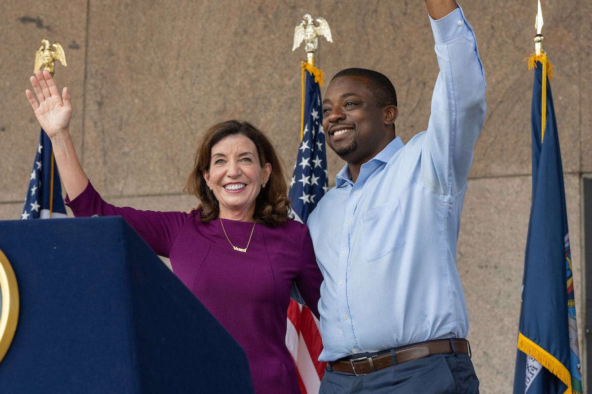 Governor Kathy Hochul (left) stands with New York Senator Brian Benjamin (right) waving.