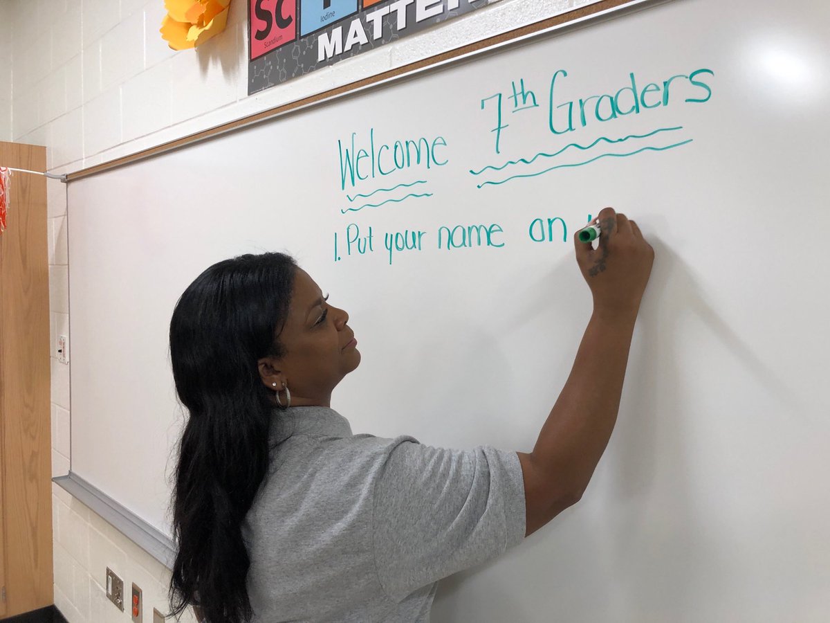 ajcdevelopment's tweet image. Dr. Erica Williams, a 7th grade life science teacher, puts up a welcome sign at McDonough Middle School Thursday. #AJCBackToSchool #ExpectExceptionalHCS