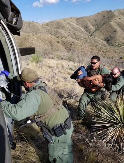 Tucson Sector Mobile Response Team Border Patrol agents rush an unconscious woman into an awaiting helicopter