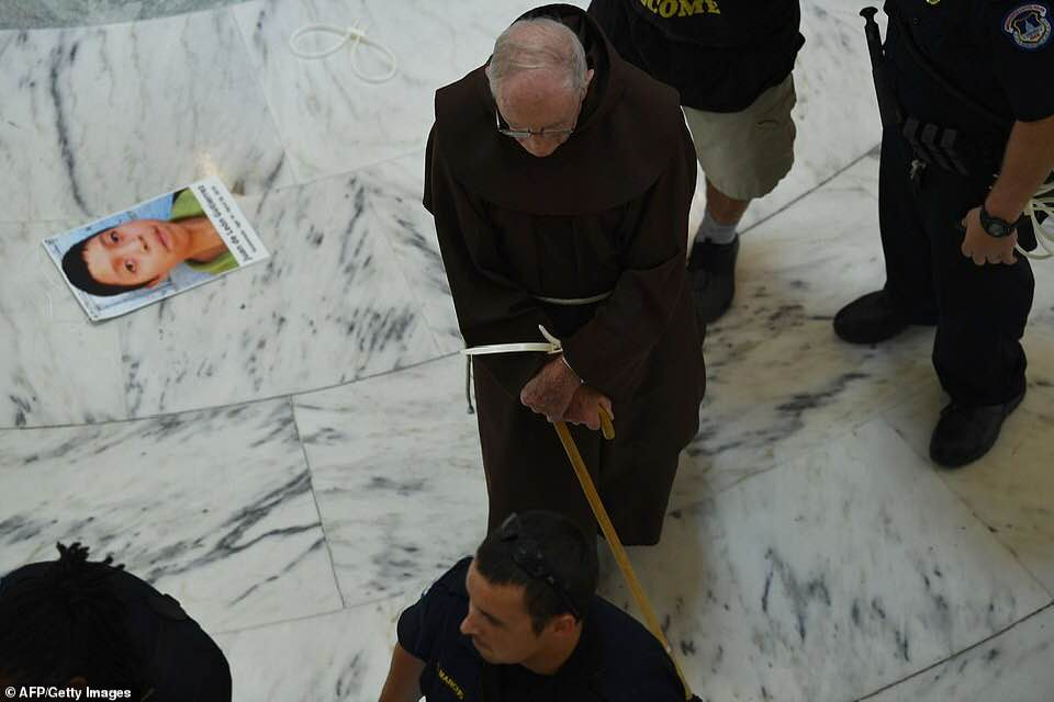 _SJPeace_'s tweet photo. This is America 

Nuns &amp; monks &amp; priests arrested for peacefully protesting against children in cages and the Separation of Children from their parents at the border.

People were wearing the faces of young children who died in these concentration camps around their necks. 💔😭 https://t.co/8f7YvdLx1h