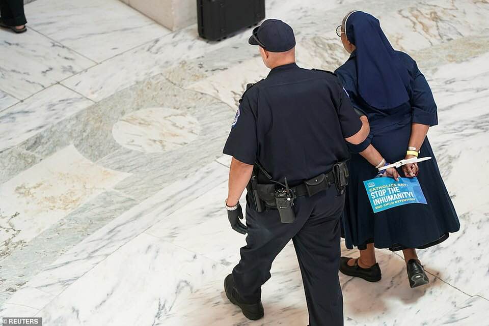 _SJPeace_'s tweet photo. This is America 

Nuns &amp; monks &amp; priests arrested for peacefully protesting against children in cages and the Separation of Children from their parents at the border.

People were wearing the faces of young children who died in these concentration camps around their necks. 💔😭 https://t.co/8f7YvdLx1h