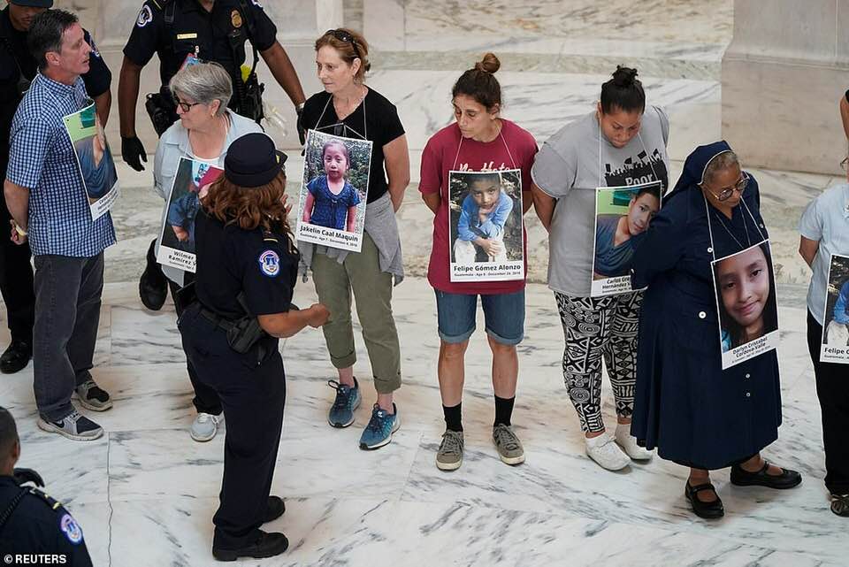 _SJPeace_'s tweet photo. This is America 

Nuns &amp; monks &amp; priests arrested for peacefully protesting against children in cages and the Separation of Children from their parents at the border.

People were wearing the faces of young children who died in these concentration camps around their necks. 💔😭 https://t.co/8f7YvdLx1h