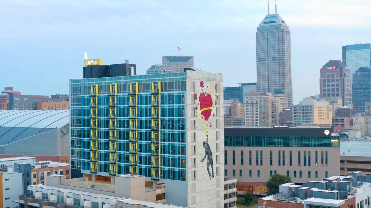 CityWayIndy's tweet photo. Nick Walker has done it again with this amazing piece titled ‘Love Conquers All’ seen on the east side of our new tower! #TheCityWay #PublicArt https://t.co/7rehOxz1G9