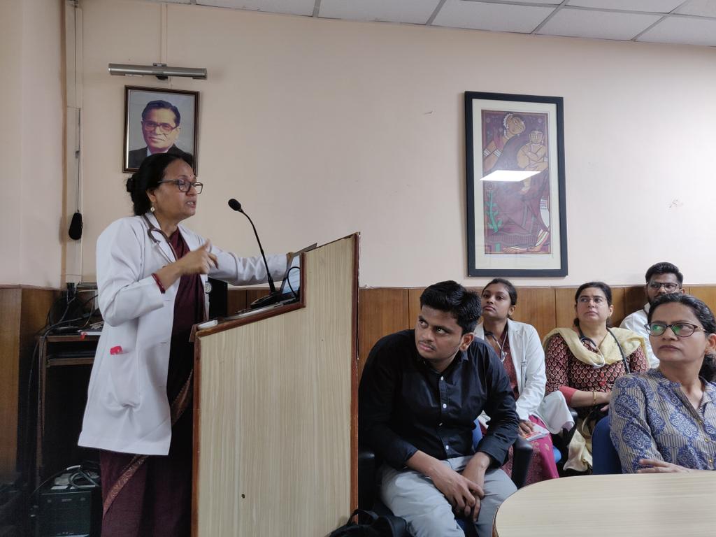 Prof Sushma Bhatnagar,Champion of palliative care addressing  the Department of Pediatrics  with Prof Ghai's photo in backdrop .House full with faculty &amp; residents on 'End of Life-Role of pediatricians'.Truly inspirational initiative  by her along with nurses for entire AIIMS🙏