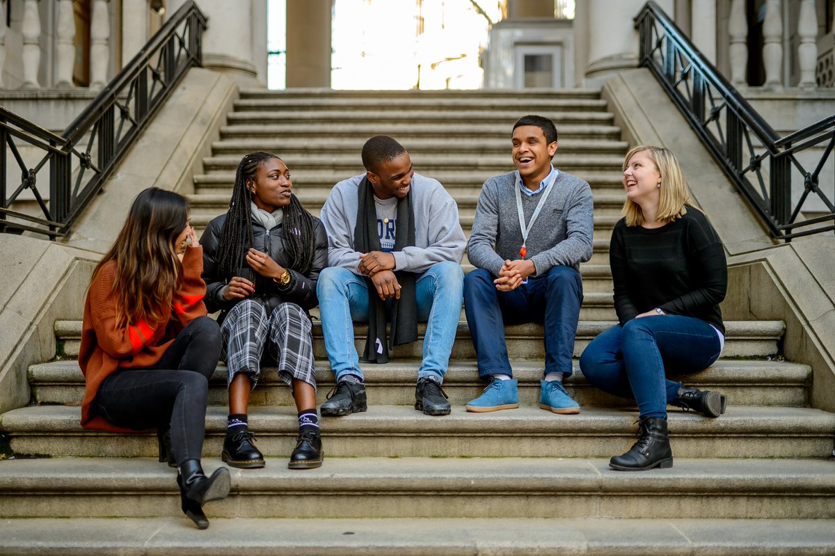 King’s College students sat on steps outside their campus building.