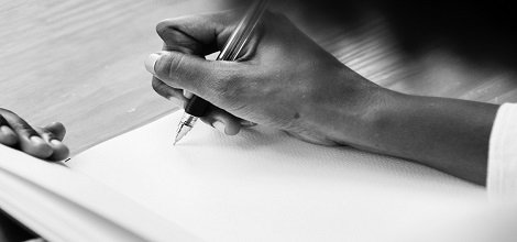 hand holding pen writing on paper