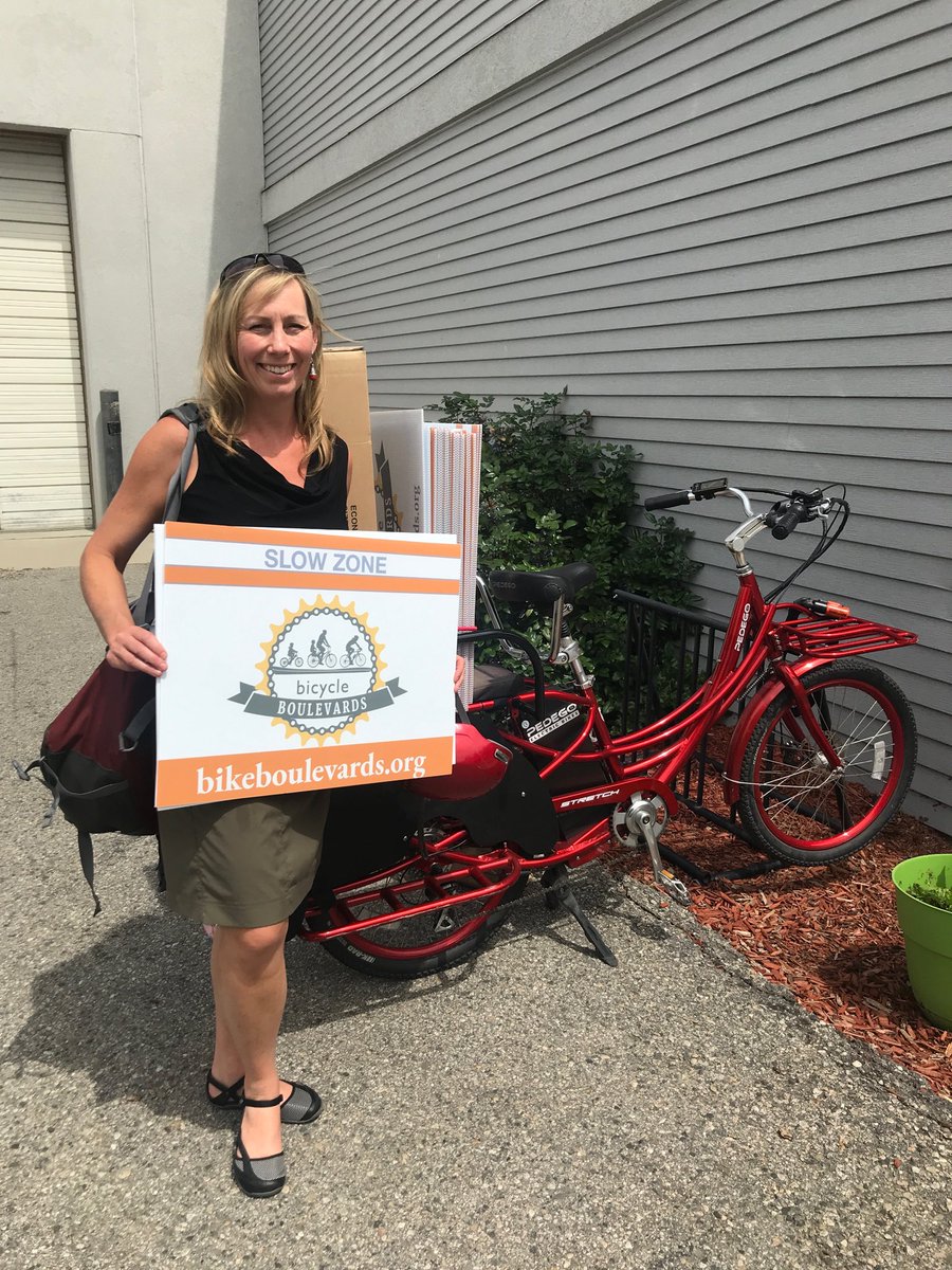 WSCsustain's tweet photo. WSC partner Deborah LaSalle shows off the new @bikeboulevards signs. This is one of our pro bono projects. We love supporting our bike community. https://t.co/kYuASbzPWV