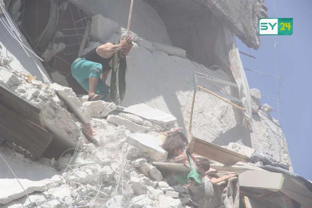 Charles_Lister's tweet image. This is 5yr-old Riham (L).

After a bomb hit her home, she was pinned into rubble 5-stories up. In this image (R), she's shown rescuing her baby sister Tuqa, who's hanging in the air by her clothes.

Riham passed away yesterday, along w. her mother &amp;amp; another sister. #Idlib #Syria