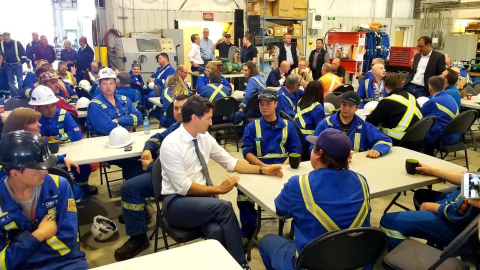 JSn0wd0n's tweet photo. This is obviously a staged photo with actors. There is no workplace in the world where everyone would have new and pressed coveralls. There isn't even one person with marks on the reflective tape. https://t.co/iXHcblK9DP