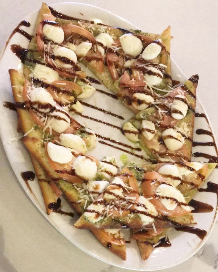 Today's flatbread special features pesto, mozzarella, tomatoes, balsamic glaze and Asiago cheese😍