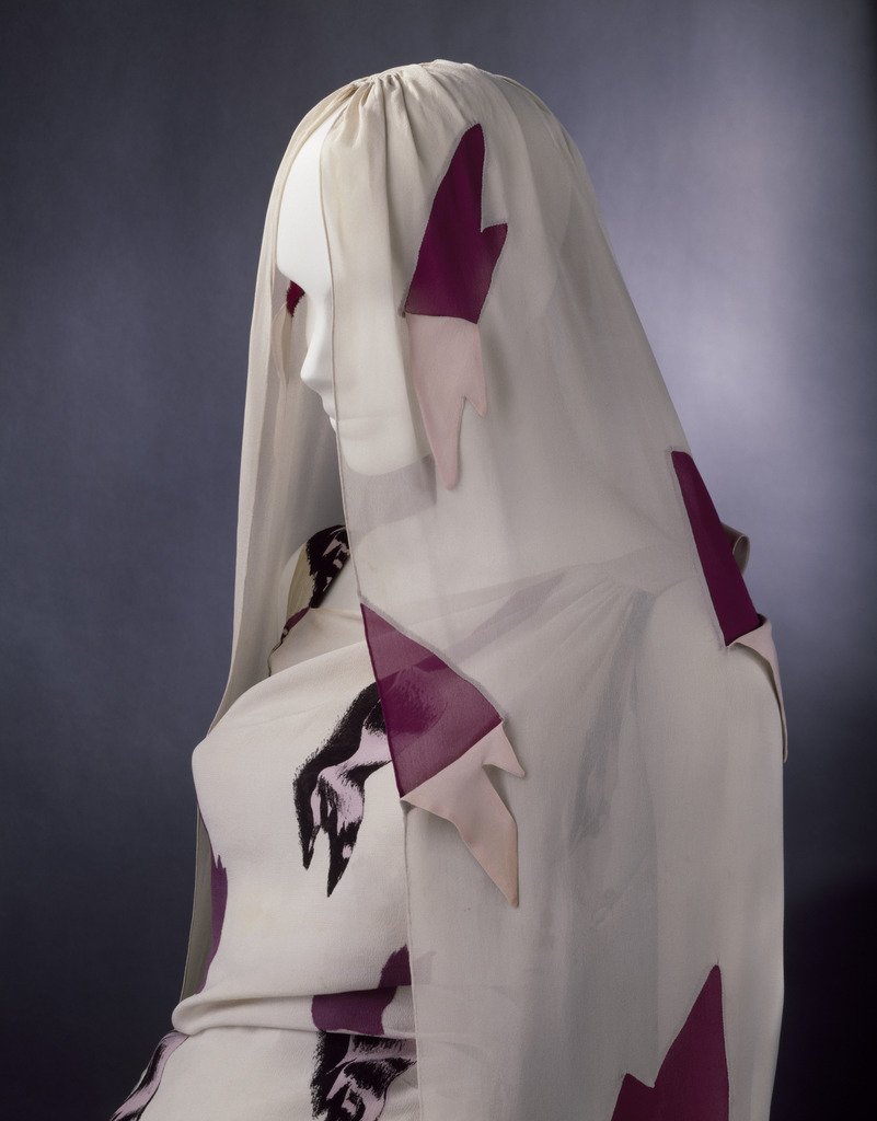 V_and_A's tweet photo. Savage rips and tears cover this Elsa Schiaparelli's slender evening gown and head-veil. A closer look reveals the illusion. The dress is printed, and the rips in the veil have been carefully cut out and lined in pink and magenta. https://t.co/EeLTz6TH4s