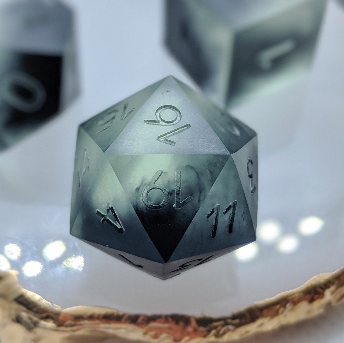 Grave's Gift with sharp edges. I'm digging the smoky tendrils of corruption in the d20. Perfect for a grave cleric or a necromancer. Numbers will be painted gold. 
.
#dnd #dice #handmadedice #diceporn