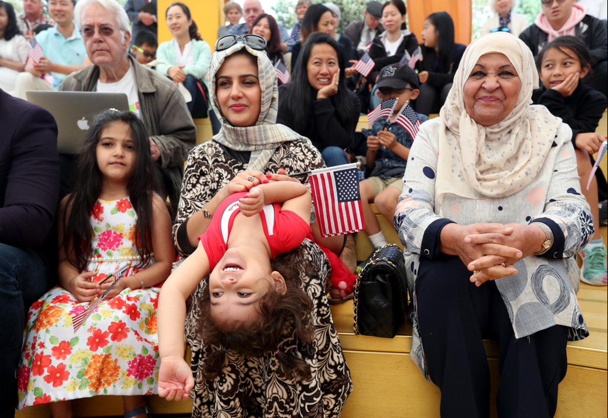 Sabreen Alabdalah, center, and her daughters Jana, 2, and Mina, 6, left, of Brentwood, and their grandmother Waheeda Alabdalah, right, take part in a children's citizenship ceremony at Children's Fairyland in Oakland, Calif., on Monday, July 29, 2019. The U.S. Citizenship and Immigration Services San Francisco Field Office swore in 24 kids from 16 countries. © (Jane Tyska/Bay Area News Group)