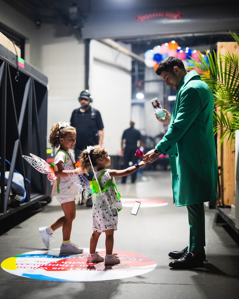 nickjonas's tweet photo. I can’t believe @jackgorlin actually caught this moment. Just a few minutes before taking the stage tonight in Atlanta tonight FaceTiming my beautiful wife @priyankachopra while getting a good luck rose from my nieces Alena and Valentina. ❤️ https://t.co/6Kp4Cr7KKB