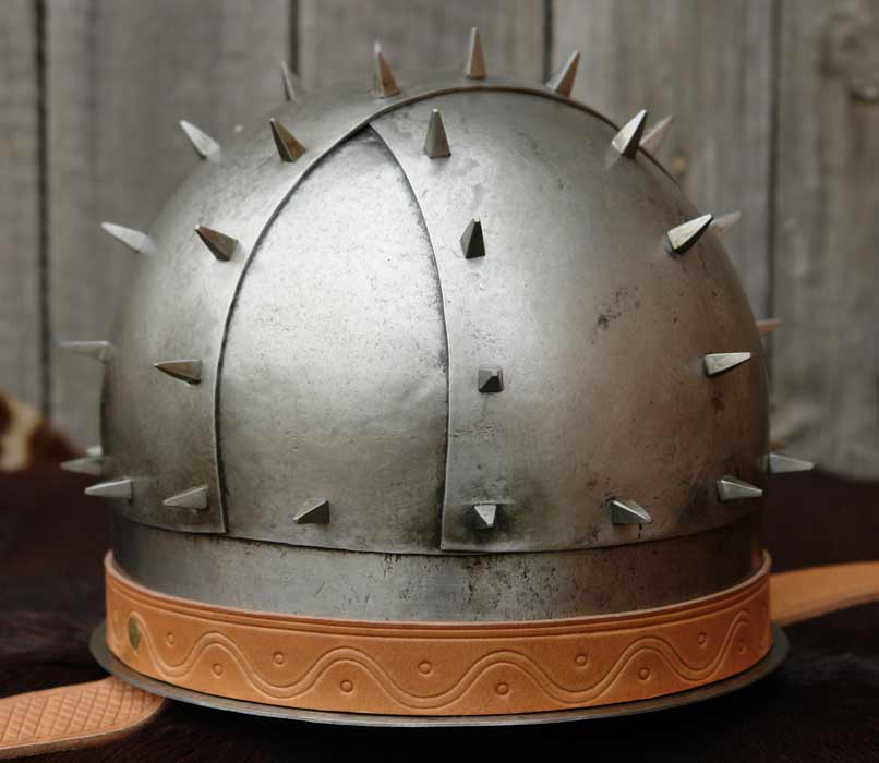 The only Bandhelm that has this feature is the one from Groningen, which dates to some time between the 6th and 8th centuries. So the influence can't come from bandhelmets.